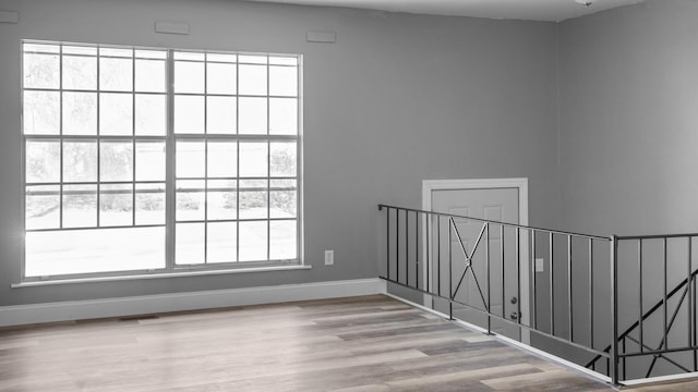 spare room featuring a wealth of natural light and light hardwood / wood-style floors