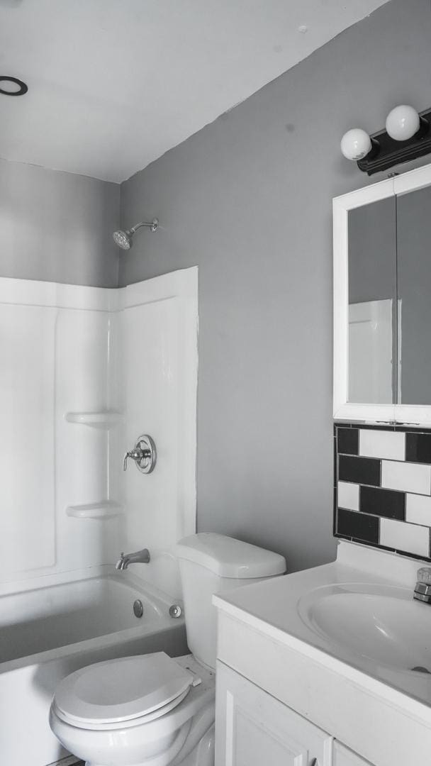 full bathroom with decorative backsplash, vanity, toilet, and shower / washtub combination