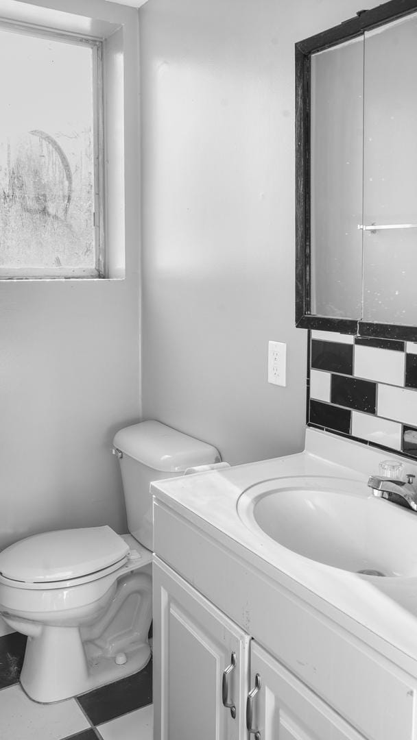 bathroom with vanity, tasteful backsplash, and toilet