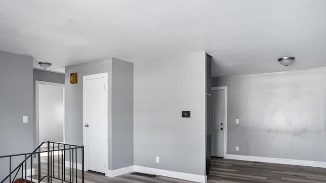 unfurnished room with dark wood-type flooring