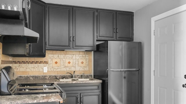 kitchen featuring decorative backsplash, extractor fan, sink, range, and stainless steel refrigerator