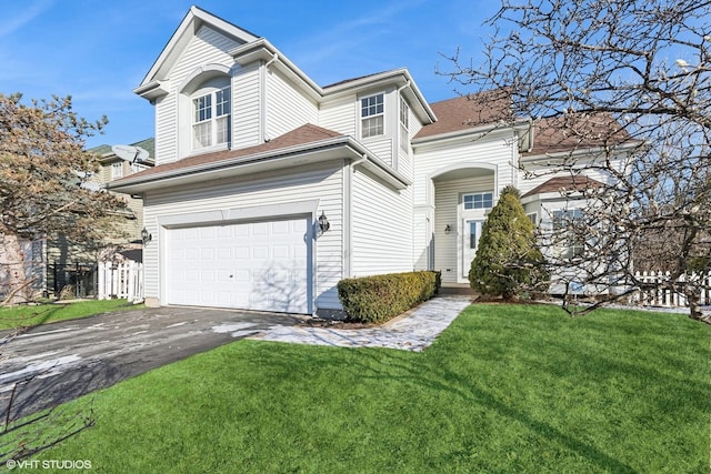 view of property featuring a garage and a front lawn