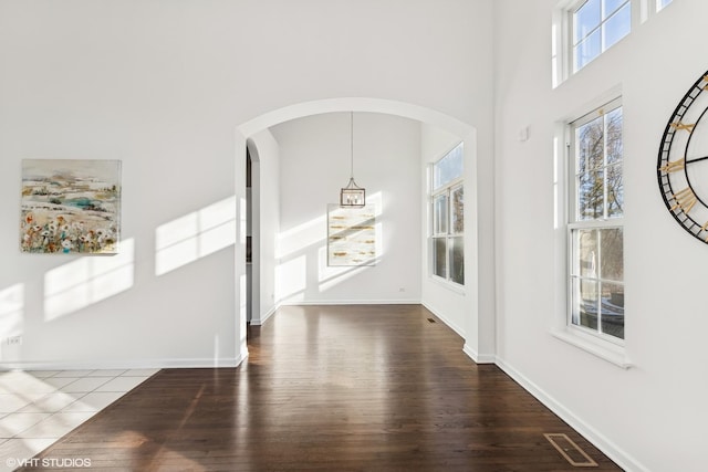 entrance foyer with a towering ceiling and hardwood / wood-style flooring