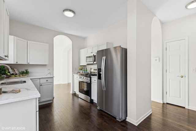 kitchen with dark wood-type flooring, sink, white cabinets, and stainless steel appliances