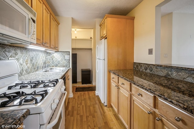 kitchen featuring a textured ceiling, sink, light hardwood / wood-style floors, and white appliances