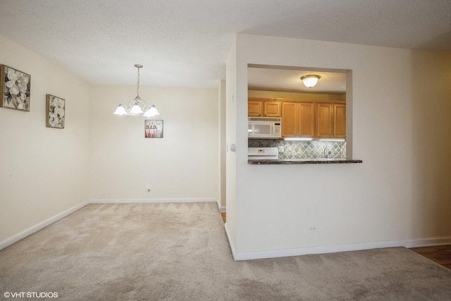 interior space featuring light carpet, a chandelier, and a textured ceiling