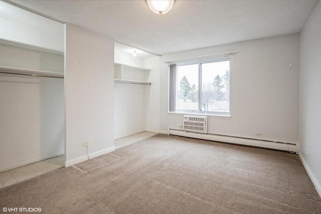 unfurnished bedroom featuring carpet, a baseboard radiator, and an AC wall unit