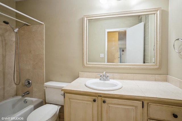 full bathroom featuring vanity, tiled shower / bath, and toilet