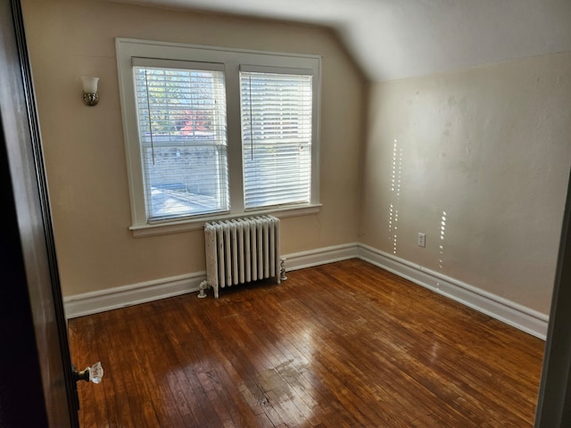 additional living space with dark wood-type flooring, radiator, and lofted ceiling