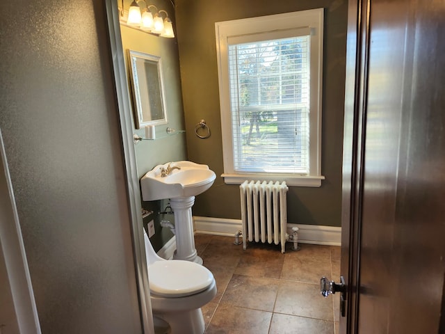 bathroom with tile patterned floors, toilet, radiator heating unit, and sink