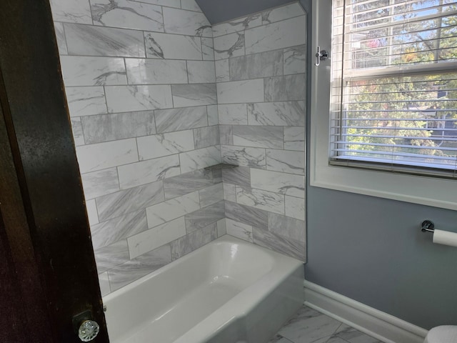 bathroom featuring plenty of natural light and tiled shower / bath