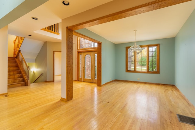 interior space with a healthy amount of sunlight, a notable chandelier, and light wood-type flooring