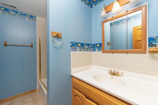 bathroom featuring tile patterned flooring, vanity, and shower / bath combination with glass door