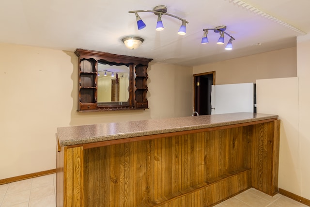 bar with white fridge and light tile patterned floors