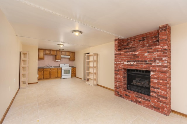 unfurnished living room featuring a fireplace and sink