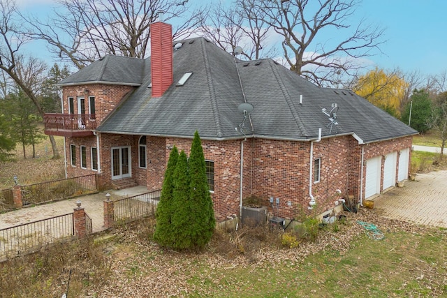 view of property exterior with a garage, a balcony, and central AC