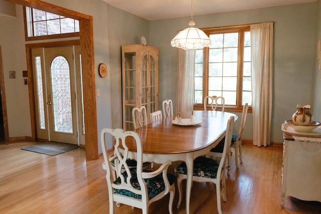 dining space with a notable chandelier and light wood-type flooring