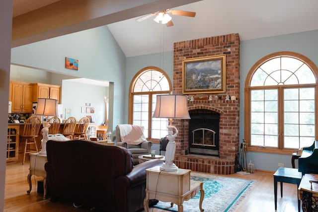 living room with a fireplace, light wood-type flooring, plenty of natural light, and ceiling fan