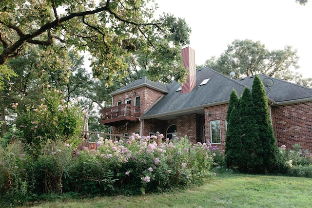 back of house featuring a yard and a balcony