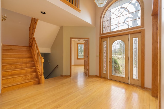 foyer entrance with a high ceiling and light hardwood / wood-style flooring