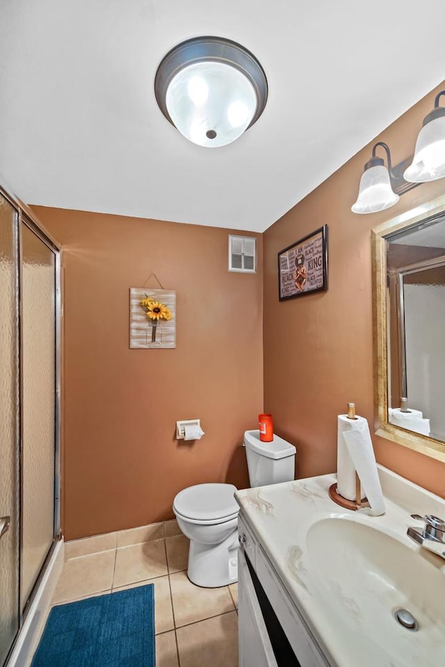 bathroom featuring tile patterned floors, vanity, toilet, and walk in shower