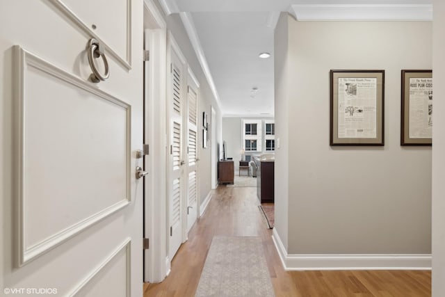 corridor featuring crown molding and light hardwood / wood-style flooring