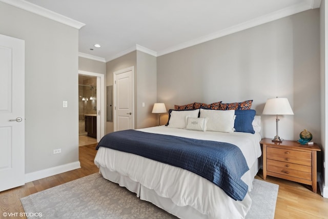 bedroom featuring hardwood / wood-style floors, ornamental molding, and ensuite bath