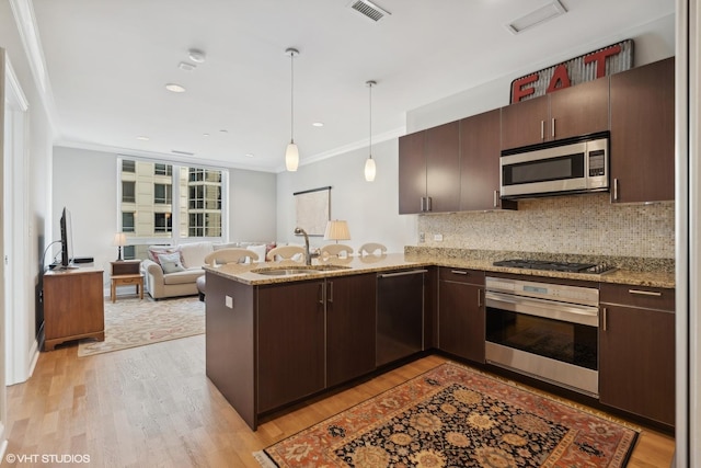 kitchen featuring sink, hanging light fixtures, kitchen peninsula, crown molding, and appliances with stainless steel finishes