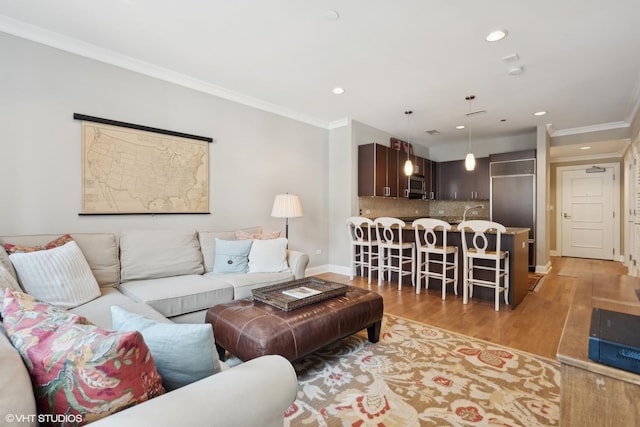 living room with crown molding and light hardwood / wood-style flooring