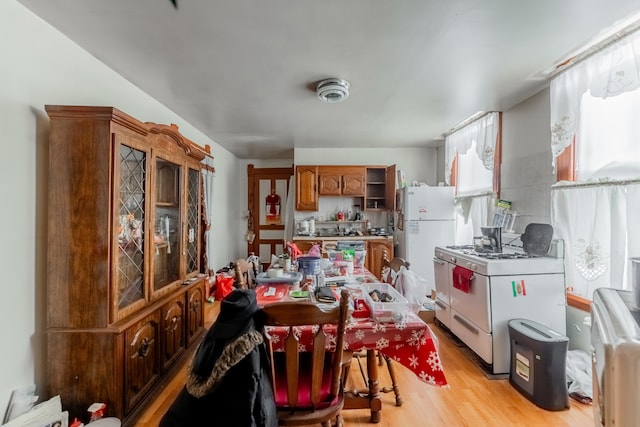 kitchen featuring white appliances and light hardwood / wood-style flooring