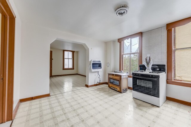 1351 N Campbell Ave, Chicago, IL 60622 - kitchen featuring white range with gas stovetop, heating unit, baseboards, and arched walkways