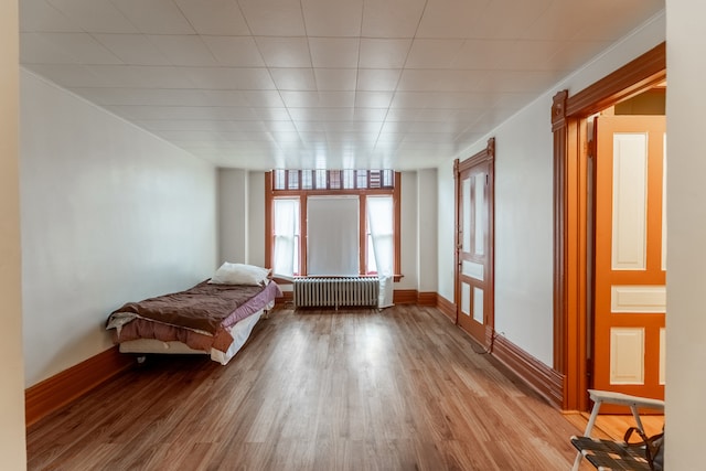 unfurnished bedroom featuring radiator heating unit, pool table, and light hardwood / wood-style flooring