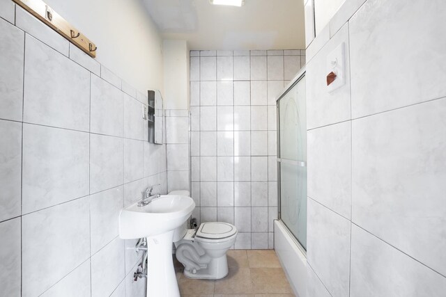 1351 N Campbell Ave, Chicago, IL 60622 - full bathroom with tile walls, toilet, tile patterned floors, and bath / shower combo with glass door