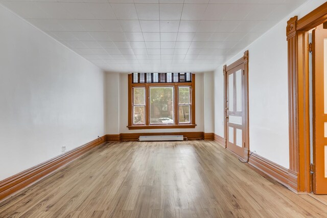 1351 N Campbell Ave, Chicago, IL 60622 - unfurnished room featuring a baseboard radiator, light wood-style floors, and baseboards