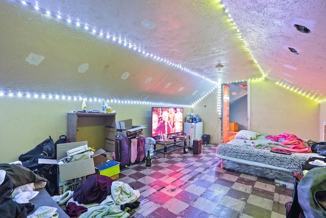 bedroom with a textured ceiling and vaulted ceiling