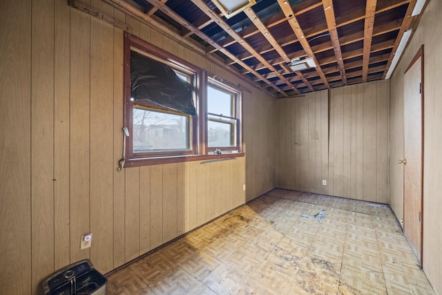 empty room featuring light parquet floors and wooden walls