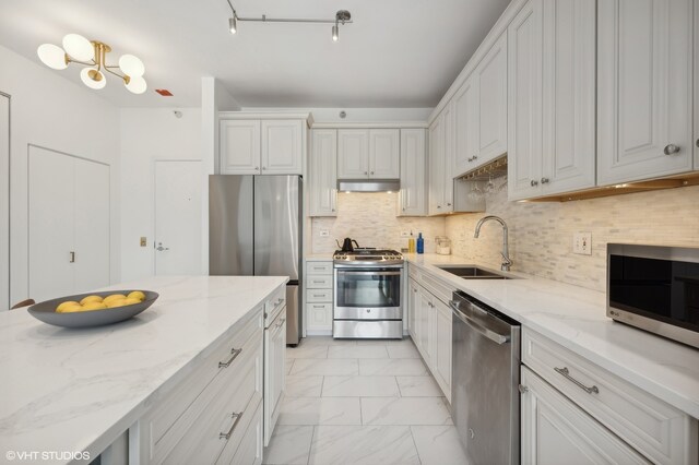 kitchen featuring white cabinetry, light stone counters, sink, and stainless steel appliances