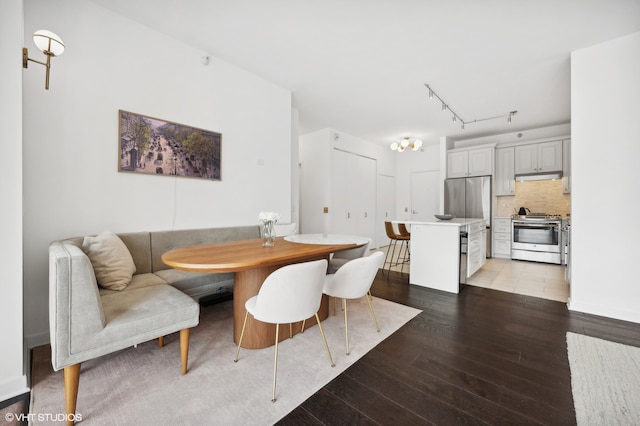 dining room featuring light hardwood / wood-style flooring, breakfast area, and track lighting