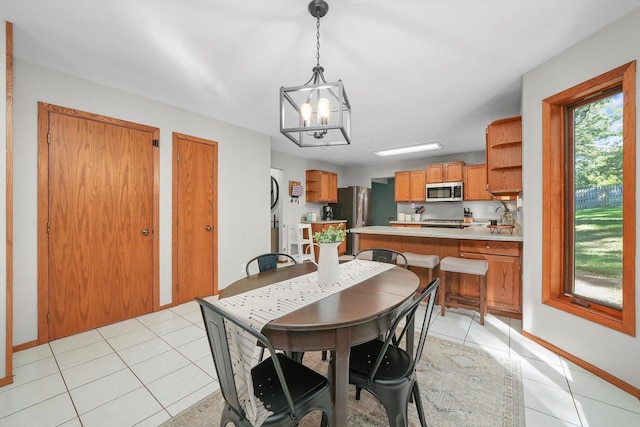 dining room with light tile patterned floors and a chandelier