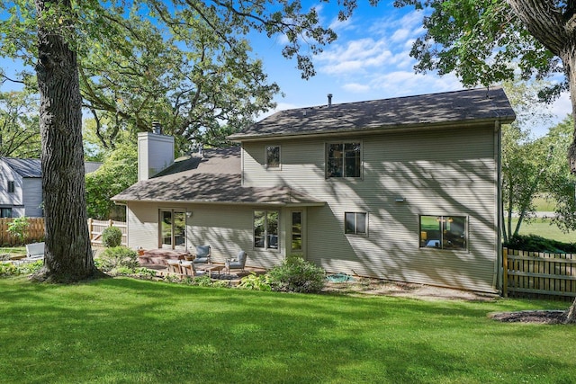 back of property featuring a patio area and a yard