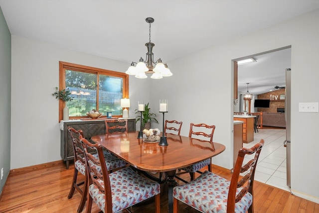 dining space with light hardwood / wood-style flooring and ceiling fan with notable chandelier