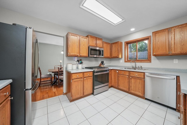 kitchen with light tile patterned flooring, stainless steel appliances, and sink