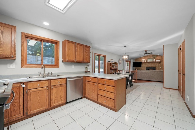 kitchen featuring kitchen peninsula, a large fireplace, sink, dishwasher, and hanging light fixtures