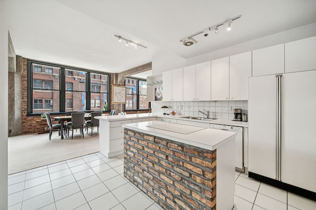 kitchen featuring light tile patterned floors, light countertops, white appliances, and a sink