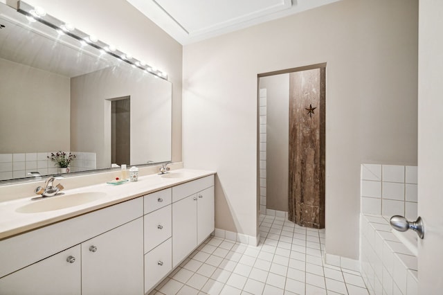 bathroom featuring double vanity, tiled bath, baseboards, tile patterned flooring, and a sink