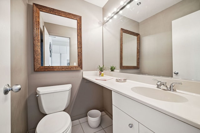 bathroom with tile patterned flooring, baseboards, vanity, and toilet