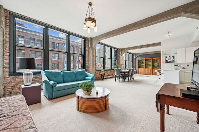 living area featuring brick wall, beamed ceiling, an inviting chandelier, and light colored carpet