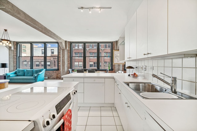 kitchen featuring light tile patterned floors, tasteful backsplash, white range with electric cooktop, light countertops, and a sink