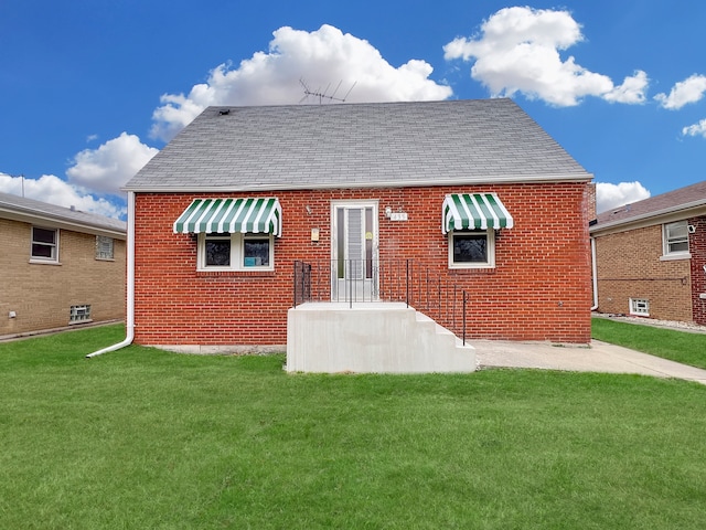 rear view of property featuring a lawn