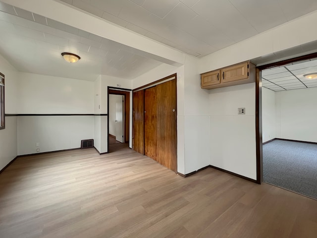 unfurnished bedroom with light hardwood / wood-style floors and a closet